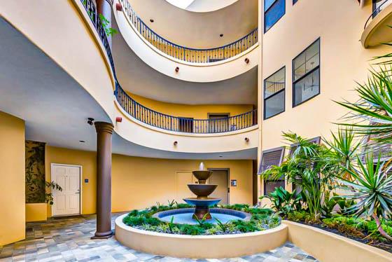 Courtyard fountain with water intrusion repair surrounded by landscaped flowerbeds with palms and native plants in Chatsworth, CA