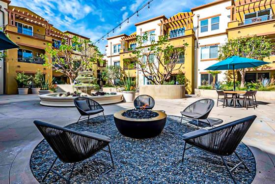 Firepit and gravel seating area in foreground with fountain in multi-family amenity in Topanga Canyon, CA