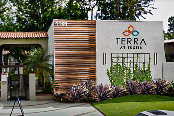 Wood cladding on a multi-family residential facade with desert plants and vines climbing a trellace outside Terra residences in Tustin, California