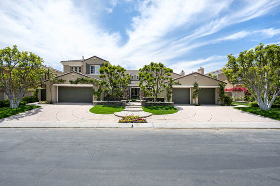 Landscaped front yard with well-placed plants, pots, poured concrete steps, a decorative wall, and prominent stone veneer